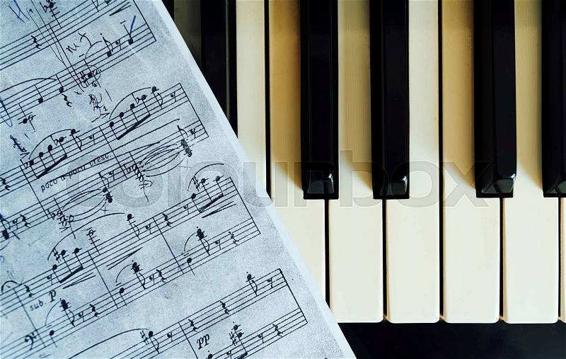 Piano keys and musical notes closeup, stock photo