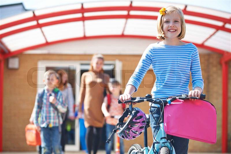 Female Pupil Pushing Bike At End Of School Day, stock photo