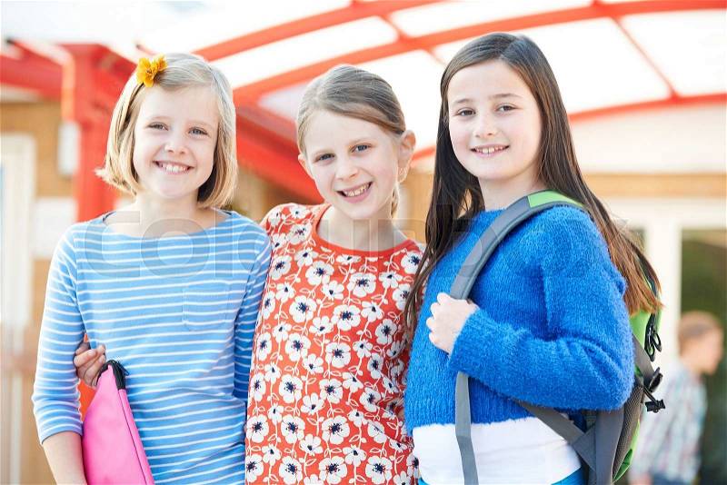 Group Of Girls Standing Outside School With Book Bags, stock photo