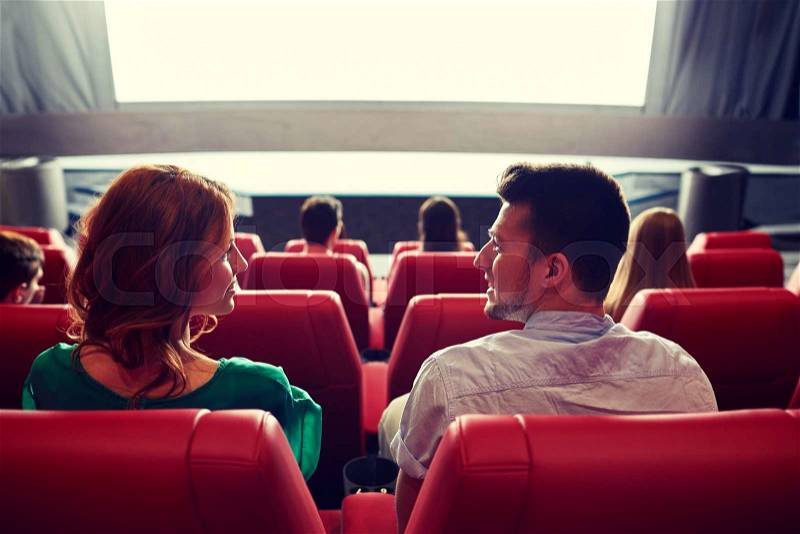 Cinema, entertainment, leisure and people concept - couple watching movie in theater from back, stock photo