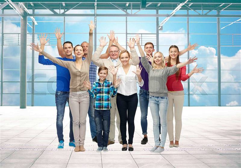 Travel, vacation and people concept - group of happy people or big family waving hands over airport terminal window and sky background, stock photo