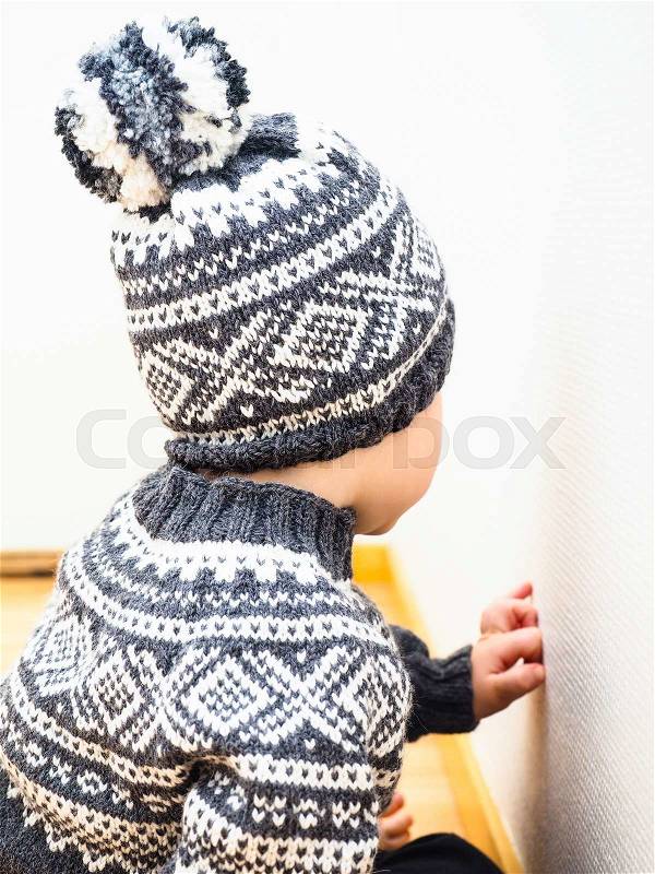 Little child with knitted clothing, hat and sweater, stock photo