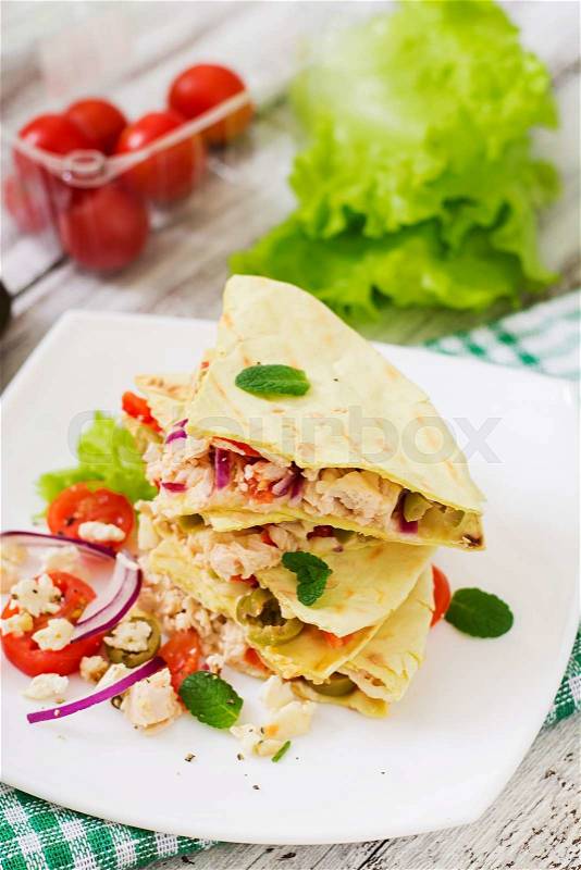 Mexican Quesadilla wrap with chicken, olives, sweet pepper and salad, stock photo