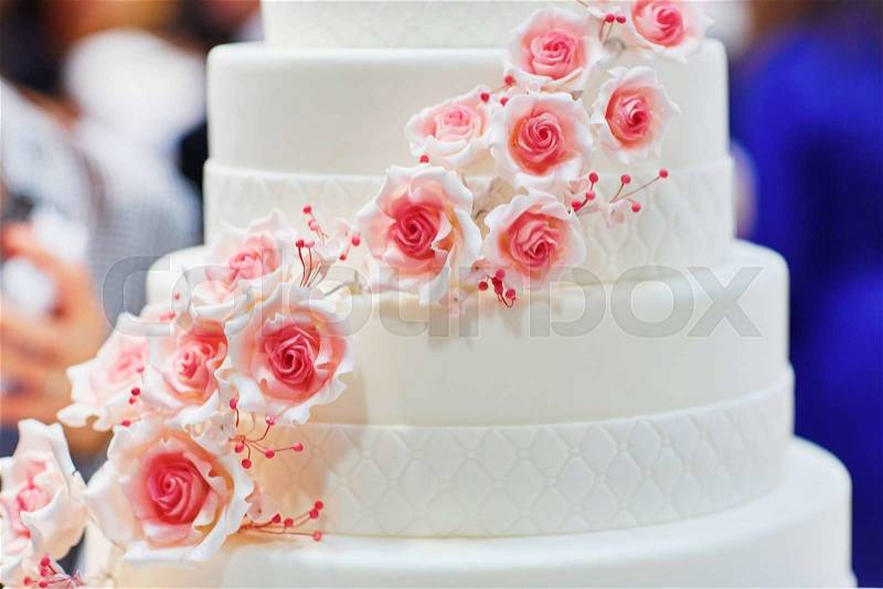 White wedding cake decorated with sugar pink roses, stock photo