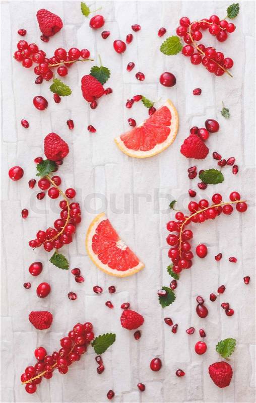 Fresh whole and sliced red fruits. Collection of fresh whole and sliced red fruits on white rustic background. Still life pattern background. Overhead view, stock photo