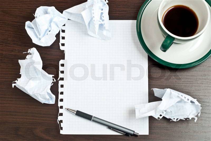 Pencil on a white paper with cup of coffee on dark desk, stock photo