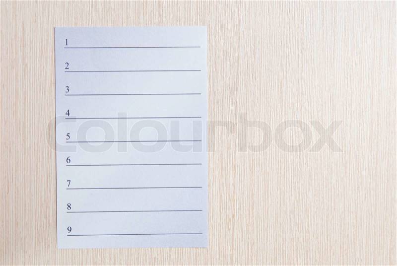 Notepad paper on wooden table. Studio shot, stock photo