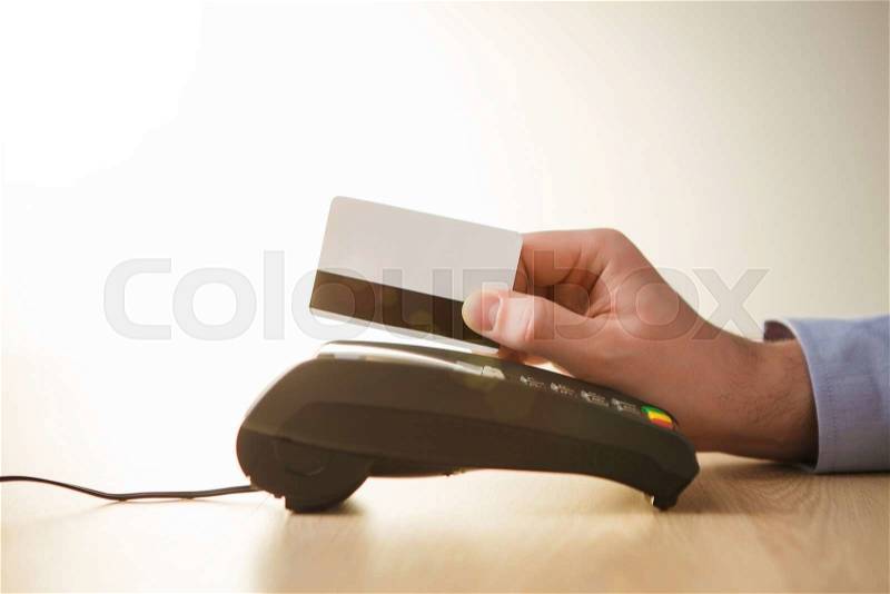 Credit card payment, buy and sell products or service. The male hand against the background of the table, stock photo