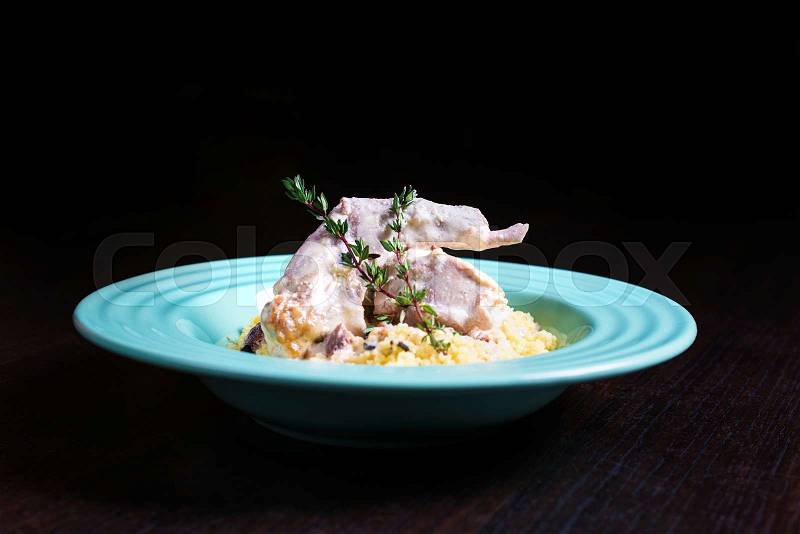 Stewed rabbit meat in creamy sauce with herbs and couscous, stock photo