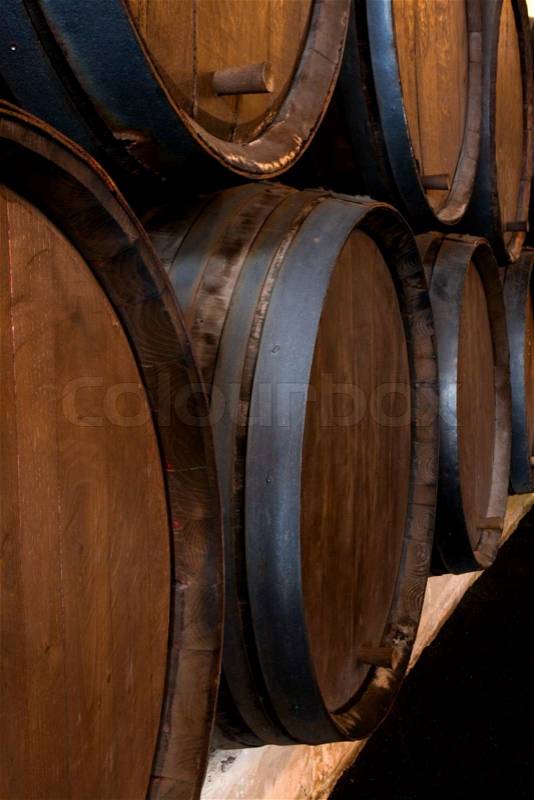 Stacked wine barrels in the wine cellar, stock photo