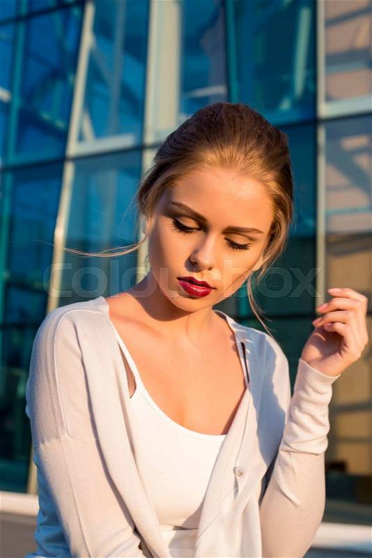 Sensitive woman. portrait on a street . glass building background, stock photo