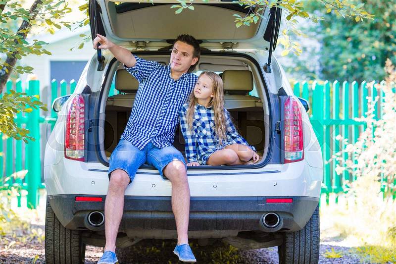 Father with daughter sitting in a car just before leaving for a car vacation, stock photo