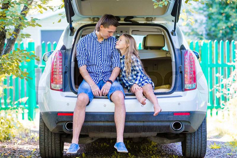 Little girl with dad sitting in a car just before leaving for a car vacation, stock photo