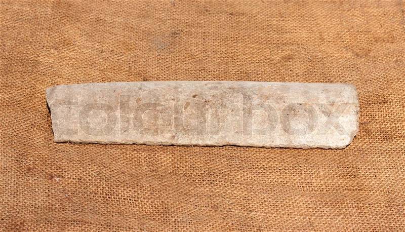 Splinter asbestos pipe on fa background of the rough sackcloth, stock photo