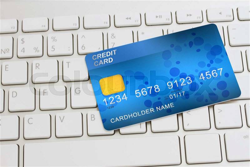 Blue plastic debit card on modern keyboard - internet shopping concept, stock photo