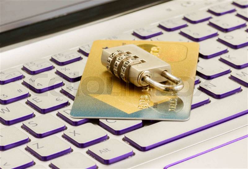 Internet transaction security concept - plastic debit card with padlock on notebook keyboard, stock photo