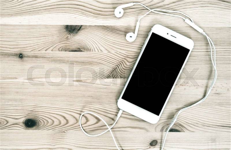 Digital mobile phone with headphones on wooden background, stock photo