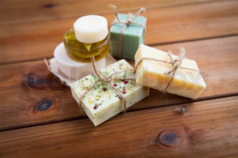 Beauty, spa, body care, bath and natural cosmetics concept - close up of handmade soap bars on wooden table, stock photo