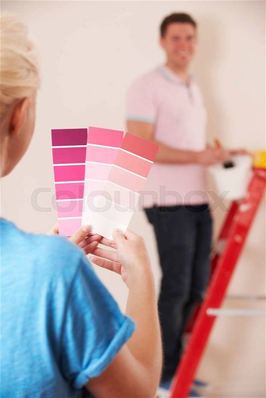 Young Couple Looking At Paint Swatches In New Home, stock photo