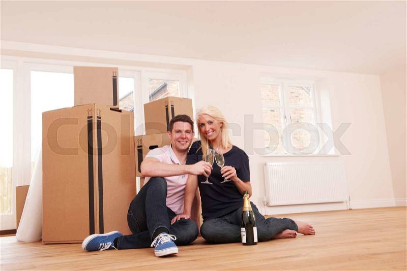 Couple Celebrating Moving Into New Home With Champagne, stock photo