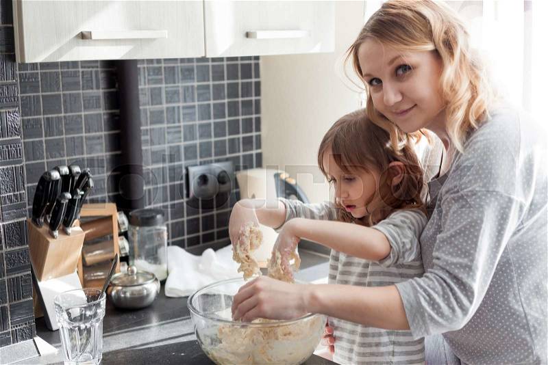 Mom with her 5 years old child cooking holiday pie in the kitchen to Mothers day, casual still life photo series, stock photo