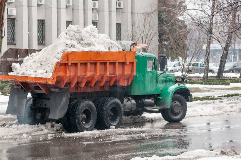 Truck transports the snow in the back in the city, stock photo