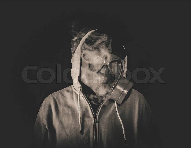 Man wearing mask and smoking,low key and monochrome, stock photo