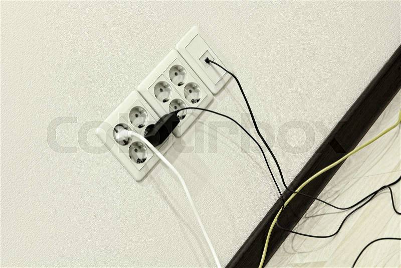 Electric sockets on home wall with cables taken closeup, stock photo