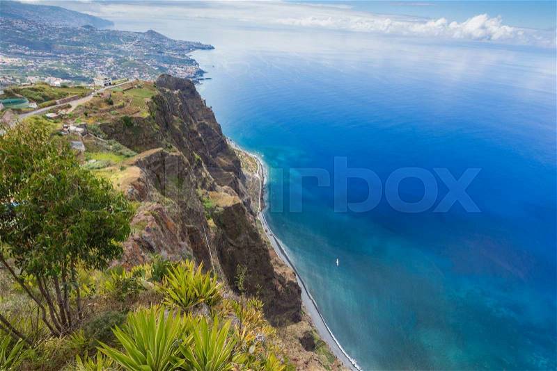 Amazing view from the highest Cabo Girao cliff on the beach, ocean water and Camara de Lobos town, Madeira island, Portugal, stock photo
