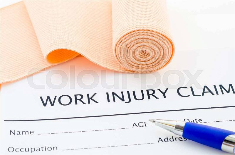Work injury claim form showing business insurance concept and medical bandage roll with pen, stock photo
