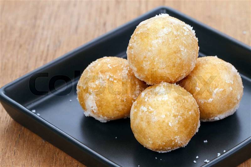Crisp sweet rice ball made from sticky rice on black plate , stock photo