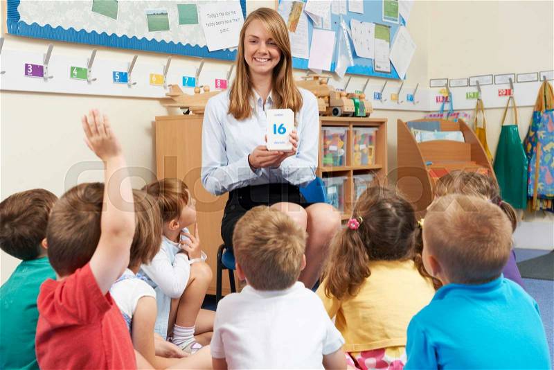 Teacher Using Flash Cards To Teach Maths To Elementary Class, stock photo