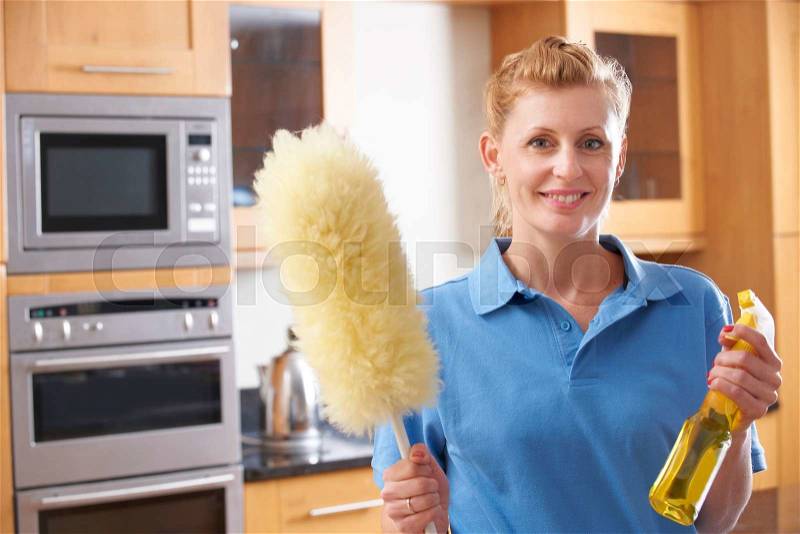 Female Cleaner Working In Kitchen, stock photo