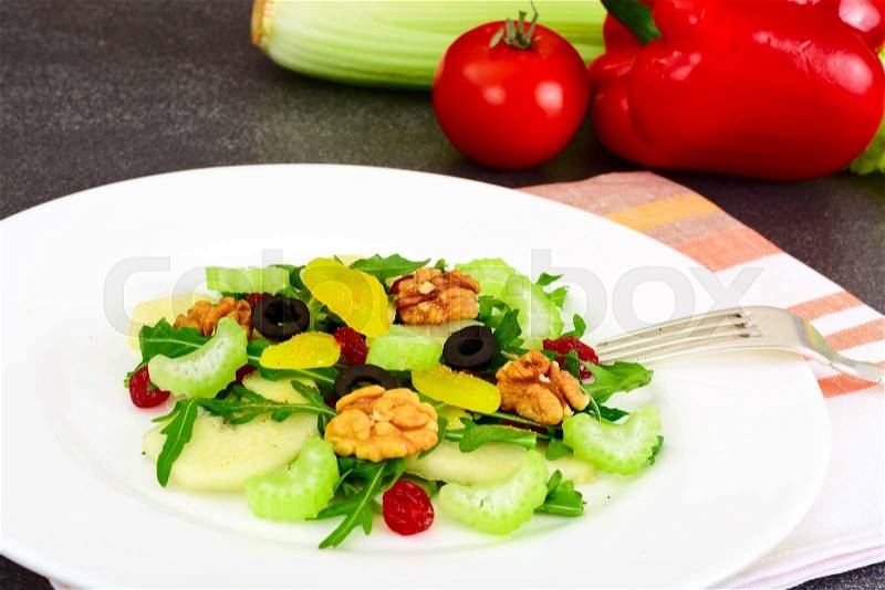 Dietary delicious salad on white plate of arugula, pear, walnut and dried cherry Studio Photo, stock photo