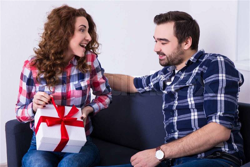 Valentine\'s day or christmas concept - happy young woman opening gift from her boyfriend, stock photo