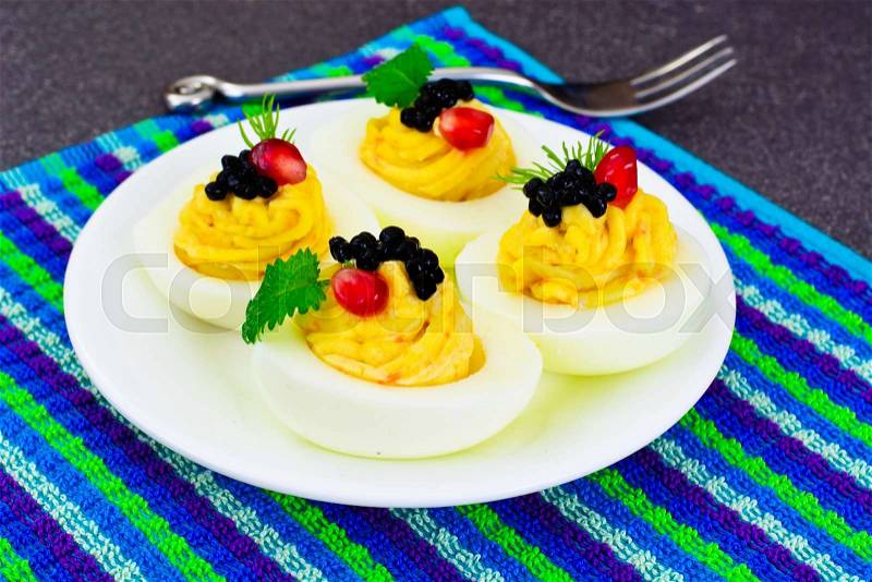 Stuffed Eggs with Pomegranate on Plate Studio Photo, stock photo