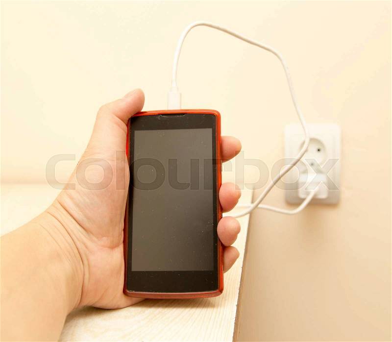 Cell phone charging in your hand, stock photo