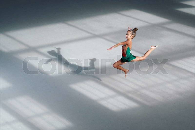 Little girl jumping gymnast trains in the sports school, stock photo