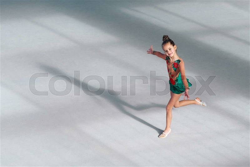 Cheerful girl gymnast performs a dance in rhythmic gymnastics, stock photo