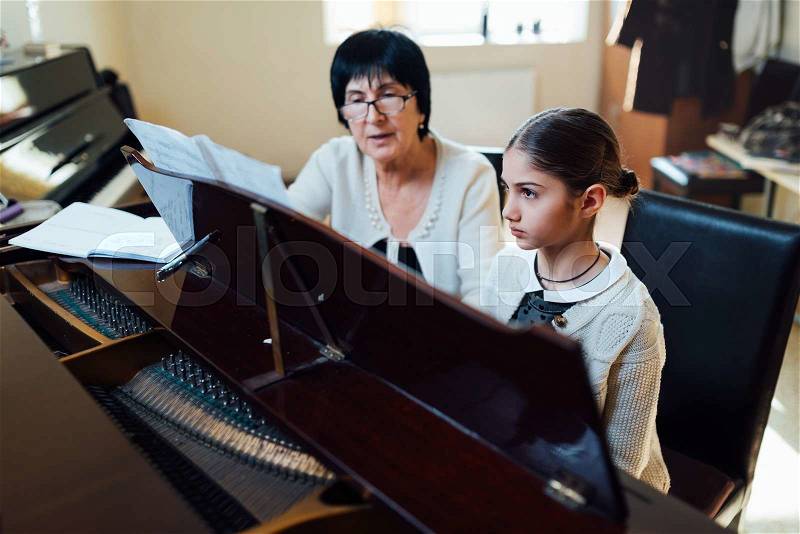 Piano lessons at a music school, teacher and student, stock photo