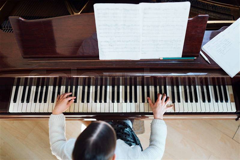 Girl playing the piano top view, stock photo