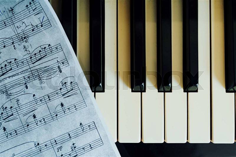 Notes and piano keys, close-up top view, stock photo