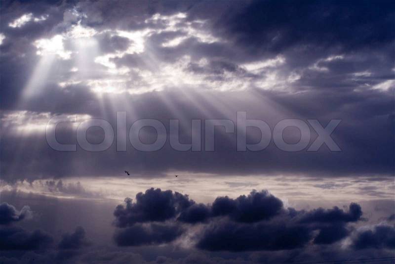 Cloudy stormy sky with sun ray breaking through, stock photo
