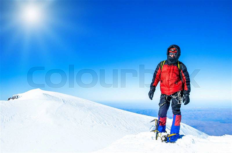 A climber reaching the summit of the mountain. Extreme sport concept, stock photo