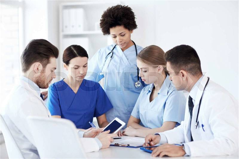 Hospital, profession, people and medicine concept - group of doctors with tablet pc computers meeting at medical office, stock photo