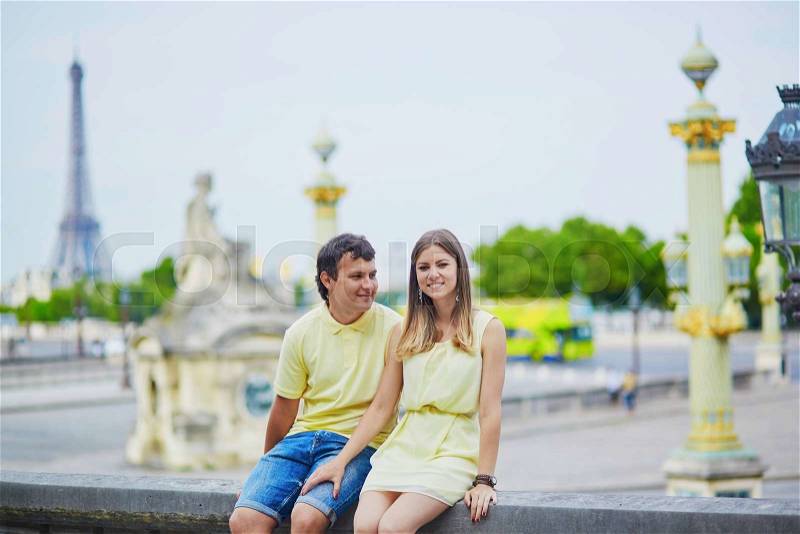Romantic dating couple of tourist in Paris in the Tuileries garden, Eiffel tower is in the background, stock photo