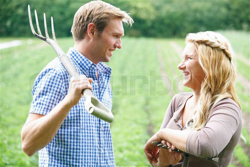 Couple Working In Field On Organic Farm, stock photo