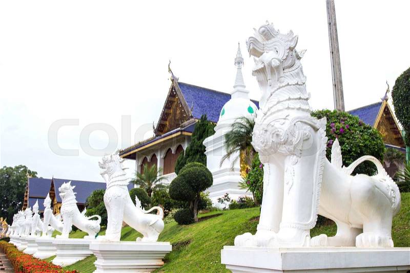White temple lion statue at place of worship with religious teachings in Chiangmai Thailand, Wat Baan Den, stock photo