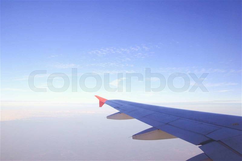 Plane wing, white clouds and blue sky, stock photo