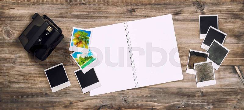 Open photo album book, camera, polaroid frames. Retro toned picture, stock photo